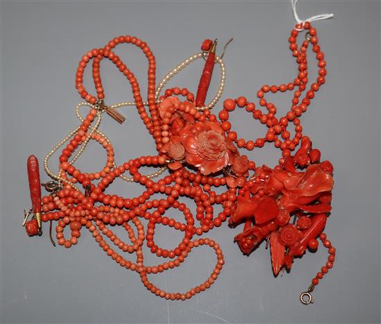 A carved coral floral spray brooch, 78mm, a triple strand coral necklace with carved floral pendant, two other coral necklace etc.